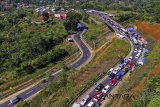 Foto udara antrean kendaraan pemudik memadati Jalur Selatan Lingkar Gentong, Kabupaten Tasikmalaya, Jawa Barat, Senin (18/6). Memasuki H+3 Lebaran arus balik di Jalur Selatan Jabar, volume kendaraan pemudik dari Jateng menuju Jakarta mulai meningkat dan mengalami kemacetan dari Jamanis hingga Limbangan, Garut. ANTARA JABAR/Adeng Bustomi/agr/18