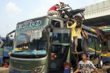 Sejumlah petugas armada bus menaikan kendaraan roda dua milik pemudik keatap bus di pool terminal Antar Lintas Sumatera, Bogor, Jawa Barat, Sabtu,(9/6). Pada h-6 jelang Idul Fitri diprediksi sebagai puncak arus mudik pertama untuk angkutan darat. ANTARA JABAR/Yulius Satria Wijaya/agr/18.
