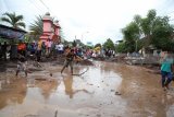 Warga membersihkan lumpur akibat banjir bandang yang melanda Banyuwangi, Jawa Timur, Jumat (22/6). Akibat banjir bandang tersebut puluhan rumah rusak dan sejumlah  ruas jalan sulit dilalui serta lahan pertanian milik warga rusak. Antara jatim/Tulus Harjono/zk/18