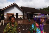 Warga dan relawan  membersihkan rumahnya dari material pasir dan lumpur akibat banjir bandang di Desa Alas Malang, Singojuruh, Banyuwangi, Jawa Timur, Sabtu (23/6). Akibat kejadian tersebut sedikitnya 328 unit rumah rusak  dan meninggalkan endapan lumpur dan pasir setinggi satu meter di pemukiman warga. Antara Jatim/Zabur Karuru/18