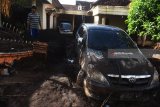 Warga membersihkan rumahnya dari material pasir dan lumpur akibat banjir bandang di Desa Alas Malang, Singojuruh, Banyuwangi, Jawa Timur, Sabtu (23/6). Akibat kejadian tersebut sedikitnya 328 unit rumah rusak  dan meninggalkan endapan lumpur dan pasir setinggi satu meter di pemukiman warga. Antara Jatim/Zabur Karuru/zk/18