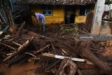 Warga membersihkan rumahnya dari material pasir dan lumpur akibat banjir bandang di Desa Alas Malang, Singojuruh, Banyuwangi, Jawa Timur, Sabtu (23/6). Akibat kejadian tersebut sedikitnya 328 unit rumah rusak  dan meninggalkan endapan lumpur dan pasir setinggi satu meter di pemukiman warga. Antara jatim/Zabur Karuru/18