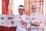 ?Calon Wakil Gubernur Jabar nomor urut empat Dedi Mulyadi (kiri) didampingi istri Anne Ratna Mustika (kanan) menunjukan surat suara saat menggunakan hak pilih di TPS 6 Purwakarta, Jawa Barat, Rabu (27/6). Pilgub Jabar diikuti empat pasang cagub dan cawagub dengan jumlah daftar pemilih tetap (DPT) sebanyak 31.735.133 pemilih. ANTARA JABAR/Agung Fatma Putra/agr/18.
