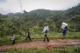 Petugas tempat pemungutan suara (TPS) memikul logistik Pilkada dari panitia pemungutan suara Desa Cilangari menuju TPS Kampung Cibuluh di perbatasan Kabupaten Bandung Barat dengan Kabupaten Cianjur, Jawa Barat, Selasa (26/6). KPU Provinsi Jawa Barat mendistribusikan logistik secara serentak ke 74 ribu TPS yang ada di 29 Kabupaten/Kota Jawa Barat jelang pemilihan umum pada (27/6). ANTARA JABAR/Raisan Al Farisi/agr/18