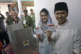 Cawagub Jatim Emil Elestianto Dardak (kanan) didampingi istri, Arumi Bachsin (kiri) menunjukkan surat suara usai menggunakan hak pilihnya di TPS 05 Kelurahan Ngantru, Trenggalek, Jawa Timur, Rabu (27/6). Emil yang maju bursa Pilkada Jatim mendampingi Cagub Khofifah Indar Parawansa mengawali rangkaian penggunaan hak pilihnya dengan sungkem ke orang tua dan ziarah makam leluhur sebelum mencoblos di TPS 05 Kelurahan Ngantru, Trenggalek. Antara Jatim/Destyan Sujarwoko/zk/18