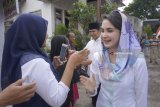 Warga menyambut Cawagub Jatim Emil Elestianto Dardak (kedua kiri) dan istrinya, Arumi Bachsin (kanan) saat berjalan menuju TPS 05 Kelurahan Ngantru, Trenggalek, Jawa Timur, Rabu (27/6). Emil yang maju bursa Pilkada Jatim mendampingi Cagub Khofifah Indar Parawansa mengawali rangkaian penggunaan hak pilihnya dengan sungkem ke orang tua dan ziarah makam leluhur sebelum mencoblos di TPS 05 Kelurahan Ngantru, Trenggalek. Antara Jatim/Destyan Sujarwoko/zk/18