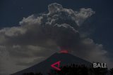 Cahaya magma dalam kawah Gunung Agung terpantul pada abu vulkanis terlihat dari Desa Datah, Karangasem, Bali, Jumat (29/6). Pusat Vulkanologi dan Mitigasi Bencana Geologi mencatat terjadinya erupsi Gunung Agung dengan tinggi kolom abu mencapai 2.000 meter namun status gunung tersebut masih pada level siaga. Antaranews Bali/Nyoman Budhiana/2018.