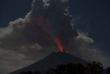Cahaya magma dalam kawah Gunung Agung terpantul pada abu vulkanis terlihat dari Desa Datah, Karangasem, Bali, Jumat (29/6/2018). Pusat Vulkanologi dan Mitigasi Bencana Geologi mencatat terjadinya erupsi Gunung Agung dengan tinggi kolom abu mencapai 2.000 meter namun status gunung tersebut masih pada level siaga. (ANTARA /Nyoman Budhiana)