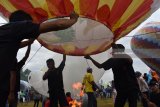 Peserta bersiap menerbangkan balon udara dengan mengisi asap api saat mengikuti Festival Balon Udara Ponorogo di Lapangan Jepun, Balong, Kabupaten Ponorogo, Jawa Timur, Kamis (21/6). Festival balon udara yang digelar Direktorat Jenderal Perhubungan Udara Kementerian Perhubungan diikuti sekitar 50 kelompok dari seluruh Kabupaten Ponorogo dimaksudkan untuk sosialisasi bermain balon yang aman dengan menggunakan tali sekaligus meminimalisir penerbangan balon udara secara liar selama perayaan Lebaran 2018. Antara Jatim/Siswowidodo/zk/18