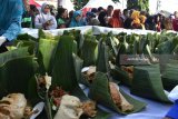 Sejumlah orang antre untuk mendapatkan nasi pecel gratis saat digelar Festival Pecel Pincuk di Kota Madiun, Jawa Timur, Jumat (22/6). Festival Pecel Pincuk yang digelar Pemkot Madiun dalam rangka memeriahkan Hari Jadi ke-100 menyajikan 16.825 pincuk nasi pecel tersebut oleh Museum Rekor-dunia Indonesia (MURI) dinyatakan sebagai terbanyak dan berhak mendapatkan sertifikat. Antara Jatim/Foto/Siswowidodo/zk/18