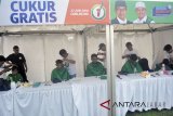 Pemangkas rambut mencukur rambut warga secara gratis saat Festival Rindu Berbuka di Lapangan Siaga, Bojonggede, Kabupaten Bogor, Jawa Barat, Selasa (5/6). Festival Rindu Berbuka yang merupakan kampanye cagub Jawa Barat nomor urut satu, Ridwan Kamil, di Kabupaten Bogor tersebut diisi dengan kegiatan ngabuburit di antaranya dengan menggelar cukur gratis, pemeriksaan kesehatan gratis, mobil curhat Avatar, pembagian takjil, dan tausyiah agama. ANTARA JABAR/Arif Firmansyah/agr/18