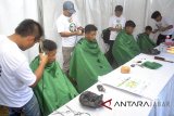 Pemangkas rambut mencukur rambut warga secara gratis saat Festival Rindu Berbuka di Lapangan Siaga, Bojonggede, Kabupaten Bogor, Jawa Barat, Selasa (5/6). Festival Rindu Berbuka yang merupakan kampanye cagub Jawa Barat nomor urut satu, Ridwan Kamil, di Kabupaten Bogor tersebut diisi dengan kegiatan ngabuburit di antaranya dengan menggelar cukur gratis, pemeriksaan kesehatan gratis, mobil curhat Avatar, pembagian takjil, dan tausyiah agama. ANTARA JABAR/Arif Firmansyah/agr/18