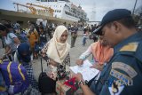 Petugas pelabuhan memeriksa identitas penumpang setibanya mereka di Pelabuhan Benoa, Denpasar, Rabu (20/6). Operasi penertiban penduduk yang melibatkan gabungan aparat itu untuk mencegah urbanisasi yang tidak terkontrol, gelandangan/pengangguran dan untuk mencegah kriminalitas di Pulau Dewata. Antaranews Bali/Nyoman Budhiana/18.