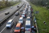 Antrean panjang kendaraan memadati keluar pintu tol Gadog, Ciawi menuju jalur Puncak, Kabupaten Bogor, Jawa Barat, Sabtu (16/6). Polres Bogor mencatat jumlah kendaraan yang masuk ke jalur wisata Puncak sebanyak 33.754 mobil pribadi yang ingin memanfaatkan libur hari raya Idulfitri 1439 H sehingga diberlakukan sistem satu arah untuk mengurangi kepadatan di kawasan tersebut. ANTARA JABAR/Arif Firmansyah/agr/18.