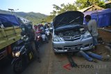 Seorang montir memperbaiki mobil pemudik yang rusak akibat tidak kuat melewati tanjakan Lingkar Gentong, Kabupaten Tasikmalaya, Jawa Barat, Senin (18/6). Dalam sehari montir di kawasan tersebut dapat memperbaiki 8-10 mobil. ANTARA JABAR/Adeng Bustomi/agr/18.
