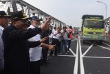 Gubernur Jawa Timur Soekarwo (kiri) menyapa pengendara yang melintasi Jembatan Widang ketika meninjau jembatan tersebut, Tuban, Jawa Timur, Rabu (6/6). Jembatan Widang kembali dibuka untuk kendaraan umum sebelumnya ambruk pada Selasa (17/4) lalu. Antara Jatim/Zabur Karuru/18
