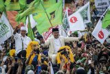 Calon Gubernur dan Wakil Gubernur Jawa Barat nomor urut satu Ridwan Kamil (kanan) dan Uu Ruzhanul Ulum (kiri) diarak menggunakan sisingaan saat kampanye akbar pasangan calon Rindu di Lapangan Tegalega, Bandung, Jawa Barat, Sabtu (23/6). Kampanye Akbar dengan tema 