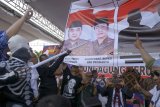 Simpatisan memeragakan cara mencoblos nomor urut 1 di poster berbentuk kertas suara, di akhir kampanye akbatr Paslon Mardiko (Margiono - Eko Prisdianto) di lapangan GOR Lembupeteng, Tulungagung, Jawa Timur, Sabtu (23/6). Menjelang coblosan 27 Juni 2018, paslon MARDIKO yang diusung koalisi 9 parpol (Partai Demokrat, PKB, Gerindra, Hanura, Golkar, PAN, PKS, PPP, dan PBB) optimistis menang dengan margin 10 persen atas kubu paslon petahana 