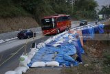 Sejumlah kendaraan melintas di ruas jalan raya Ponorogo-Trenggalek Km 32 yang rusak parah akibat longsor di Desa Pangkal, Ponorogo, Jawa Timur, Sabtu (16/6). Memasuki H+1 arus balik kendaraan pemudik terpantau mulai meningkat di jalur selatan Jatim via Tulungagung-Trenggalek-Ponorogo-Madiun meski kondisi infrastruktur sempit dan sebagian ruas rusak parah terdampak longsor. Antara Jatim/Destyan Sujarwoko/zk/18