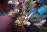 Warga mengantre untuk mendapatkan hidangan ketupat gratis di Kampung Sukolilo, Kenjeran, Surabaya, Jawa Timur, Jumat (22/6). Tradisi Lebaran Ketupat yang dirayakan pada hari ketujuh setelah Hari Raya Idul Fitri bagi warga di kampung tersebut dimeriahkan dengan membagikan hidangan ketupat secara gratis kepada warga lainnya. Antara Jatim/Moch Asim/18