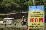 Pemudik melintas disamping jalan yang longsor di jalur altenatif Sumedang-Subang, Rancakalong, Kabupaten Sumedang, Jawa Barat, Selasa (12/6). Longsor akibat intensitas hujan yang tinggi pada beberapa bulan lalu tersebut hingga H-3 Hari Raya Idulfitri 1439 H belum diperbaiki. ANTARA JABAR/Raisan Al Farisi/agr/18