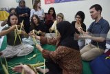 Sejumlah mahasiswa asing asal Amerika Serikat belajar merangkai kulit ketupat ketika kunjungannya di STIE Perbanas Surabaya, Jawa Timur, Selasa (26/6). Kegiatan dalam rangka 