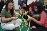 Sejumlah mahasiswa asing asal Amerika Serikat belajar merangkai kulit ketupat ketika kunjungannya di STIE Perbanas Surabaya, Jawa Timur, Selasa (26/6). Kegiatan dalam rangka 