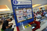 Calon penumpang berada di dekat fasilitas pengecekan keaslian uang milik Bank Indonesia di Ruang Tunggu Bandara Adi Soemarmo, Boyolali, Jateng, Kamis (21/6/2018). Pemasangan alat tersebut untuk memudahkan masyarakat mengecek keaslian uang serta meminimalisir peredaran uang palsu. (ANTARA FOTO/Wahyu Putro A) 