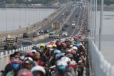 Pengendara motor melintasi Jembatan Suramadu, Surabaya, Jawa Timur, Rabu (13/6). Pada H-2 Lebaran, jembatan penghubung antara Pulau Jawa dengan Pulau Madura mulai dipadati kendaraan khususnya pengendara motor yang menuju ke Pulau Madura. Antara Jatim/Zabur Karuru/18