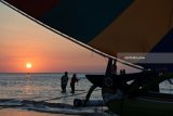 Pengunjung bermain perahu layar di Pantai Pasir Putih Situbondo, Jawa Timur, Minggu (17/6). Masyarakat memanfaatkan libur Lebaran dengan menikmati matahari terbenam, berenang di laut, naik perahu layar dan bermain kano. Antara Jatim/Seno/zk/18.