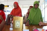 Sejumlah warga antre untuk menerima Alquran yang diwakafkan PT Pelindo I, di Terminal Penumpang Bandar Deli, Belawan, Medan, Sumatra Utara, Kamis (7/6/2018). PT Pelindo I mewakafkan 2.500 Alquran sekaligus menyerahkan santunan kepada warga masyarakat Belawan. (ANTARA FOTO/Irsan Mulyadi)