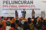 Presiden Joko WIdodo (tengah) berbincang dengan Direktur Utama BRI Suprajarto (kanan) serta seorang pelaku UMKM di sela-sela peluncuran aturan penurunan tarif Pajak Penghasilan Final 0,5 persen bagi UMKM di Surabaya, Jawa Timur, Jumat (22/6). Kebijakan tersebut bertujuan untuk mendorong pelaku UMM agar lebih ikut berperan aktif dalam kegiatan ekonomi formal serta meningkatkan ketahanan ekonomi Indonesia. Antara Jatim/Zabur Karuru/18