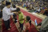 Plh Gubernur Jawa Barat Iwa Karniwa (kedua kiri) membagikan zakat kepada mustahik di Masjid Raya Provinsi Jawa Barat di Bandung, Kamis (14/6) malam. Masjid Raya Jawa Barat membagikan zakat fitrah kepada 3.000 mustahik pada malam menjelang Hari Raya Idulfitri 1439H. ANTARA JABAR/Raisan Al Farisi/agr/18