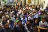 Sejumlah warga menunjukkan kupon ketika antre untuk mendapatkan zakat mal di kawasan Kalimas Madya Surabaya, Jawa Timur, Senin (11/6). Pembagian zakat mal yang dibagikan oleh seorang pengusaha biro perjalanan kepada 2.000 orang dengan nominal sekitar Rp100.000 hingga Rp200.000. Antara jatim/M Risyal Hidayat/zk/18