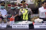 Pj Bupati Tulungagung Jarianto (kiri) dan Kapolres Tulungagung AKBP Tofik Sukendar (kedua kanan) memeriksa barang bukti minuman keras ilegal dan narkoba saat digelarnya seremoni pemusnahan ribuan botol minuman keras, narkoba dan BB alat judi di halaman Pemkab Tulungagung, Jawa Timur, Rabu (6/6). Sejak kurun Januari hingga Mei 2018, total sudah 431 pelaku peredaran miras, narkoba dan perjudian ditangkap aparat kepolisian setempat sebagai bagian perang melawan peredaran minuman keras ilegal dan narkoba. Antara jatim/Destyan Sujarwoko/zk/18