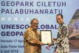 Gubernur Jawa Barat Ahmad Heryawan (kiri) memberikan penghargaan kepada Direktur Utama bank BJB Ahmad Irfan (kanan) saat penetapan dan syukuran Geopark Ciletuh Palabuhanratu di Gedung Sate, Bandung, Jawa Barat, Minggu (3/6). Unesco menetapkan Geopark Ciletuh Palabuhanratu menjadi Unesco Global Geopark. ANTARA JABAR/M Agung Rajasa/agr/18.
