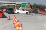 Petugas mengatur lalulintas kendaraan di persimpangan pintu keluar dan masuk Jalan Tol Fungsional Ngawi-Wilangan, Nganjuk, Jawa Timur, Kamis (14/6). Meningkatnya volume kendaraan di tol Wilangan-Ngawi pada H-1 Lebaran membuat kendaraan harus bergantian untuk keluar ataupun masuk di jalan tol tersebut. Antara Jatim/Ari Bowo Sucipto/zk/18.