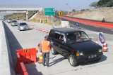 Petugas mengatur lalulintas kendaraan di persimpangan pintu keluar dan masuk Jalan Tol Fungsional Ngawi-Wilangan, Nganjuk, Jawa Timur, Kamis (14/6). Meningkatnya volume kendaraan di tol Wilangan-Ngawi pada H-1 Lebaran membuat kendaraan harus bergantian untuk keluar ataupun masuk di jalan tol tersebut. Antara Jatim/Ari Bowo Sucipto/zk/18.