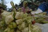 Pedagang musiman mununggui cangkang ketupat dagangannya di Pasar 17 Agustus Pamekasan, Jawa Timur, Kamis (21/6). Mereka menawarkan dagangannya memanfaatkan momentum lebaran ketupat dengan harga  Rp4000 hingga Rp5000 per ikat isi 10 cangkang. Antara Jatim/Saiful Bahri/zk/18