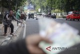 Penyedia jasa penukaran uang menawarkan penukaran uang di sepanjang Jalan Merdeka, Bandung, Jawa Barat, Senin (11/6). Mendekati Hari Raya Idulfitri 1439 H, penyedia jasa penukaran uang mulai menjamur dengan menjajakan uang pecahan dari Rp2.000 hingga Rp 20.000 dengan mengambil keuntungan sekitar 10 persen dari nominal uang yang ditukarkan. ANTARA JABAR/Raisan Al Farisi/agr/18