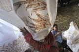 Perajin menyelesaikan pesanan batik tulis di Paoman, Indramayu, Jawa Barat, Minggu (3/6). Perajin mengaku pesanan batik untuk bahan busana Lebaran meningkat hingga 70 persen dibanding bulan biasanya. ANTARA JABAR/Dedhez Anggara/agr/18.