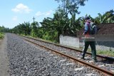 Petugas Penilik Jalan (PPJ) kereta api  Mohammad Riski berjalan memeriksa keamanan rel kereta api di Kelurahan Banjarsari, Glagah, Banyuwangi, Jawa Timur, Selasa (12/6). Selama arus balik dan mudik Lebaran 2018 petugas PPJ tersebut setiap hari memeriksa jalur rel kereta api sepanjang enam kilometer dari Stasiun Argopuro ke Stasiun Karangasem pulang pergi dengan mengecek baut kendur, bantalan rel rusak, lidah wesel rusak, longsoran, pohon tumbang, dan rintangan jalan rel kereta api. Antara Jatim/Seno/zk/18.