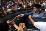 Presiden Joko Widodo (kanan) memberikan cinderamata pada warga usai melaksanakan ibadah shalat Jumat di Masjid Nasional Al-Akbar Surabaya, Jawa Timur, Jumat (22/6). Kegiatan tersebut salah satu rangkaian dari kunjungan kerja Presiden Joko Widodo di  Jawa Timur yakni peluncuran Pajak Penghasilan (PPh) final usaha mikro, kecil dan menengah (UMKM) 0,5 persen dan peresmian ruasjalan tol Gempol-Rembang, Pasuruan Jawa Timur. Antara Jatim/M Risyal Hidayat/zk/18