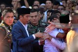 Warga berusaha menyalami Presiden Joko Widodo (kedua kiri) usai melaksanakan ibadah shalat Jumat di Masjid Nasional Al-Akbar Surabaya, Jawa Timur, Jumat (22/6). Kegiatan tersebut salah satu rangkaian dari kunjungan kerja Presiden Joko Widodo di  Jawa Timur yakni peluncuran Pajak Penghasilan (PPh) final usaha mikro, kecil dan menengah (UMKM) 0,5 persen dan peresmian ruasjalan tol Gempol-Rembang, Pasuruan Jawa Timur. Antara Jatim/M Risyal Hidayat/zk/18