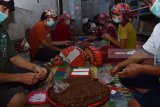 Pekerja membungkus jenang di industri rumahan jenang dan dodol di Kepatihan Kota, Ponorogo, Jawa Timur, Sabtu (2/6). Menurut pemilik industri rumahan tersebut, selama Ramadan hingga menjelang Lebaran, kapasitas produksi jenang dan dodol berbagai jenis, antara lain jenang dan dodol ketan, beras, kentang, waluh, mangga, nanas, kacang hijau, pisang meningkat 1.000 persen, dari rata-rata 300 hingga 500 kotak karton berisi tiga ons per kotak menjadi 5.000 kotak karton perhari. Namun harga tetap stabil Rp17.500 per kotak karton. Antara Jatim/Foto/Siswowidodo/zk/18