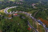 Foto udara antrean kendaraan pemudik memadati Jalur Selatan Lingkar Gentong, di Kabupaten Tasikmalaya, Jawa Barat, Selasa (19/6). H+4 Lebaran diprediksi menjadi puncak arus balik Lebaran di Jalur Selatan Jabar, dengan volume kendaraan pemudik dari Jateng menuju Jakarta mulai meningkat serta mengalami kepadatan dan antrean dari Rajapolah hingga Limbangan, dan sebagian pemudik dialihkan melalui jalur selatan Garut. ANTARA JABAR/Adeng Bustomi/agr/18.