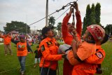 Seorang anak mencoba permainan flying fox yang disediakan BPBD di Rest Area Mudik Alun-alun Ciamis, Jawa Barat, Kamis (14/6). BPBD Kabupaten Ciamis menyediakan tempat hiburan permainan flying fox untuk pemudik saat arus mudik dan arus balik yang melintasi Jalur Selatan Jabar. ANTARA JABAR/Adeng Bustomi/agr/18