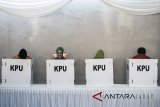 Calon Gubernur Jawa Barat nomor urut satu Ridwan Kamil (kiri) bersama istri Atalia Praratya (kedua kiri) menunjukan surat suara saat menggunakan hak pilihnya di TPS 21 Bandung, Jawa Barat, Rabu (27/6). Pilgub Jabar diikuti empat pasang cagub dan cawagub dengan jumlah daftar pemilih tetap (DPT) sebanyak 31.735.133 pemilih. ANTARA JABAR/M Agung Rajasa/agr/18.
