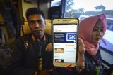 Penumpang menunjukan aplikasi Layanan Pengaduan Online Rakyat (LAPOR) saat diadakannya sosialisasi aplikasi Lapor di Terminal Leuwipanjang, Bandung, Jawa Barat, Rabu (13/6). Aplikasi yang digagas oleh Kemenpan RB tersebut ditujukan agar masyarakat dapat menyampaikan pengaduan mengenai berbagai permasalahan terkait pelayanan publik terutama saat arus mudik. ANTARA JABAR/Raisan Al Farisi/agr/18.