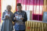 Calon Gubernur Provinsi Jawa Barat Sudrajat (kanan) beserta istri Sally Salziah (kiri) menunjukkan surat suara sebelum menggunakan hak suaranya pada Pilkada Jawa Barat 2018 di TPS 27 Hegarmanah, Bandung, Jawa Barat, Rabu (27/6). Sudrajat merupakan Calon Gubernur Provinsi Jawa Barat yang berpasangan dengan Ahmad Syaikhu dan diusung oleh Partai Gerindra, PKS dan PAN untuk memimpin Jawa Barat Periode 2018-2023. ANTARA JABAR/Novrian Arbi/agr/18